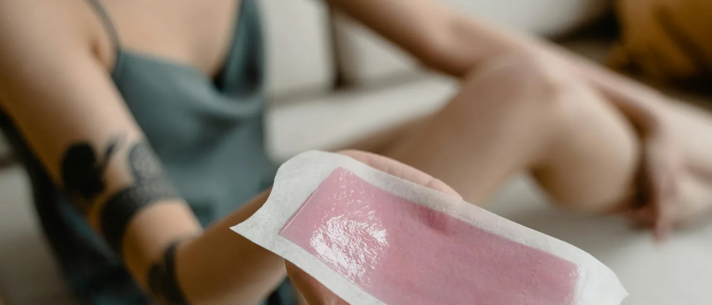 Hand holding a hair-removal wax strip — book sugaring or waxing in Vaughan at Veloura